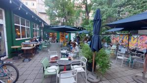 an outdoor patio with tables and chairs and umbrellas at Home S in Zagreb
