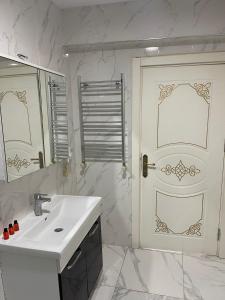 La salle de bains blanche est pourvue d'un lavabo et d'une porte. dans l'établissement AVRASYAQUEEN HOTEL, à Istanbul 74 autres photos