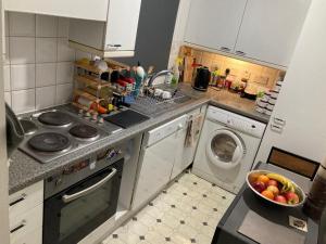 a kitchen with a washing machine and a bowl of fruit at LIMEHOUSE upon THAMES ROOM IN Great location in London