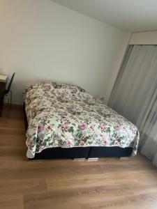 a bed in a bedroom with a floral blanket at Apartment in Bern city centre in Bern
