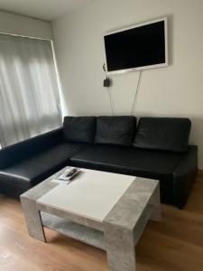 Apartment in Bern city centre في برن: غرفة معيشة مع أريكة سوداء وطاولة