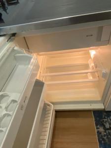 an empty refrigerator with its door open in a kitchen at Apartment in Bern city centre in Bern