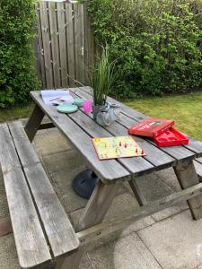 una mesa de picnic de madera con utensilios para escribir. en Comfortabel 6-persoons huisje nabij strand, bos, duinen en stad, en Warmenhuizen