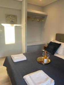 a bedroom with a bed and a tray with a bottle of wine at Wave Luxury Apartments in Kassiopi