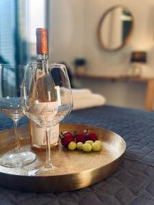 una botella de vino y algunas uvas en un plato en Wave Luxury Apartments, en Kassiopi