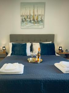 a tray with a bottle of wine and a glass on a bed at Wave Luxury Apartments in Kassiopi