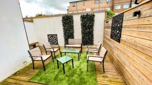 d'une terrasse avec des chaises, des tables et une clôture. dans l'établissement Surbiton Luxury Garden House 19, à Surbiton