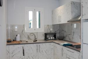Una cocina con encimeras de mármol blanco y un fregadero. en Wave Luxury Apartments, en Kassiopi 27 fotos más