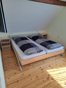 a large bed in a room with a wooden floor at Gästehaus Six Inn mit Gemeinschaftsküche bis 6 Personen in Uttenweiler