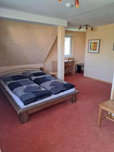 ein großes Schlafzimmer mit einem Bett und einem Tisch in der Unterkunft Gästehaus Six Inn mit Gemeinschaftsküche bis 6 Personen in Uttenweiler