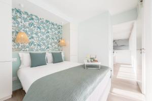 una camera con un letto bianco e una parete blu e verde di BORA BORA free parkplace ad Annecy