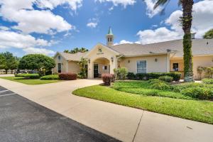 a house with a driveway and a church at Ocala Home with Screened-In Porch and Community Perks! in Marion Oaks