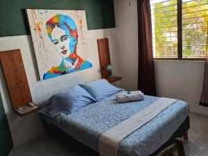 1 dormitorio con 1 cama con una pintura en la pared en Tu Casa en el Caribe en Cancún