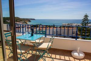 balcón con mesa, sillas y vistas al océano en Casa do Mar en Salema