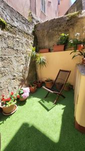 um pátio com uma cadeira e vasos de plantas em Itiseasy Cuglieri 1 e 2 Private Apartments em Cuglieri