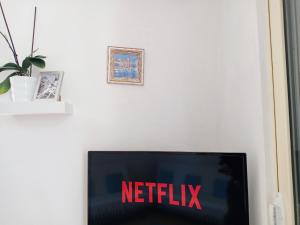 une télévision avec un panneau netflix sur un mur dans l'établissement Kristi Apartment, à Saranda