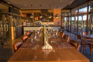 une longue table en bois dans un restaurant avec des chaises dans l'établissement Midland Hotel & Resort All Inclusive, à Paso de los Toros