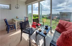 ein Wohnzimmer mit einem Sofa, Stühlen und einem Tisch in der Unterkunft Lovely Home In Nyhamnslge With House Sea View in Nyhamnsläge