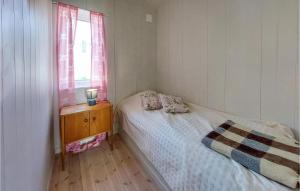 ein kleines Schlafzimmer mit einem Bett und einem Fenster in der Unterkunft Lovely Home In Nyhamnslge With House Sea View in Nyhamnsläge
