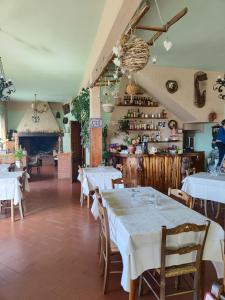 un restaurante con mesas y sillas blancas y una cocina en Albergo Ristorante La Selva en Orsigna