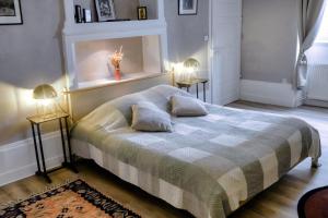 1 dormitorio con 1 cama con 2 mesas y 2 lámparas en La Verrière - Chambre d'hôtes et gîte de charme en Poligny