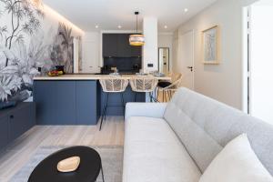 een woonkamer met een bank en een keuken bij KENYA parking gratuit in Annecy