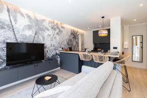 een woonkamer met een bank en een tv bij KENYA parking gratuit in Annecy