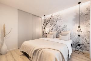 a bedroom with a large bed with a painting on the wall at CASABLANCA free parking in Annecy