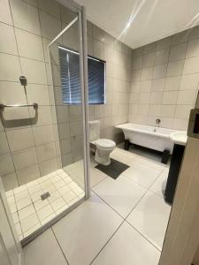 une salle de bains avec douche, toilettes et lavabo dans l'établissement Priceless Cove. Garden Cottage, à Midrand 9 autres photos