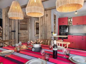 ein Esszimmer mit einem Tisch mit roten Schränken in der Unterkunft Appartement neuf et spacieux, idéal pour familles, proche des pistes et calme montagnard - FR-1-570-14 in Levassaix + 9 Fotos
