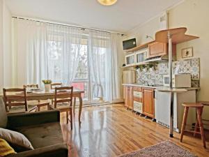 een keuken en een woonkamer met een tafel, een keuken en een eetkamer bij Apartament Kameralny 14 in Gdańsk