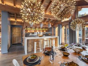 a dining room with a table and chandeliers at Chalet de prestige au cœur de Saint Martin de Belleville, à quelques pas des pistes - FR-1-570-38 in Saint-Martin-de-Belleville +12 photos