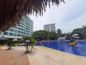 una piscina en un complejo con un elefante en el agua en Costa Azul Suites 401, en Santa Marta