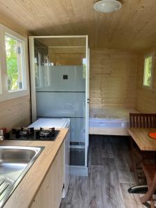 uma cozinha com um fogão, um lavatório e uma banheira em Camping Le Canoë em Chaussin