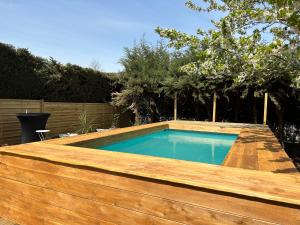 una piscina en un patio trasero con una valla de madera en La Salamandre de l Olivier - Le Laurier en Aubignosc