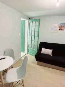 sala de estar con sofá, mesa y sillas en Grand appartement périphérie de Paris et N1 "Appart'6", en Pierrefitte-sur-Seine