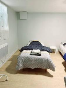 Un dormitorio con una cama con una manta. en Grand appartement périphérie de Paris et N1 "Appart'6", en Pierrefitte-sur-Seine