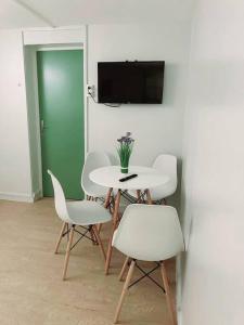 Habitación con mesa, sillas y TV. en Grand appartement périphérie de Paris et N1 "Appart'6", en Pierrefitte-sur-Seine