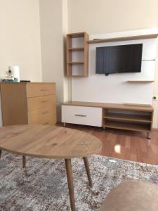 a living room with a table and a tv at BEŞ YILDIZ APART in Trabzon