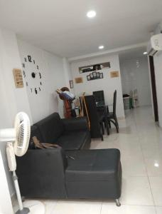 uma sala de estar com um sofá e um relógio na parede em Bright Duplex 2 bedroom Apartment, kitchen, bathroom & living room em Cartagena de Indias