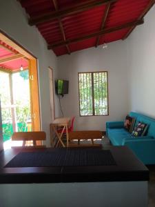 a living room with a blue couch and a table at Bosque Azul Picaflor in Minca