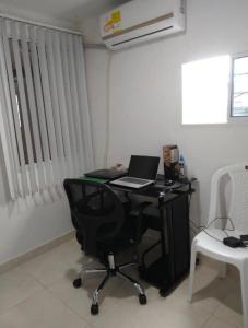 a desk with a laptop computer on it in a room at Bright Duplex 2 bedroom Apartment, kitchen, bathroom & living room in Cartagena de Indias