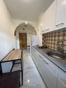 a kitchen with a sink and a wooden table at Karlsburg Studio in Alba Iulia