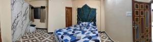 um quarto com uma cama azul e branca em Sharif's Penthouse em Hyderabad