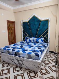 um quarto com uma cama azul e branca em Sharif's Penthouse em Hyderabad