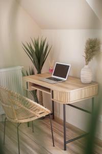 a desk with a laptop and a chair in a room at Le Wim' - Appart neuf proche plage et centre ville in Wimille