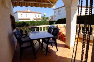 une table et des chaises sur un balcon avec une maison dans l'établissement Miami Playa: houses / villas - 4 rooms - 6 persons, à Mont-roig
