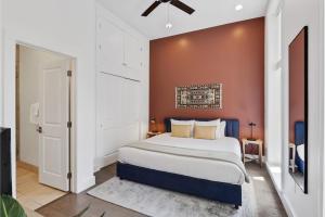 a bedroom with a large bed and a red wall at Roami at Bourbon Place in New Orleans