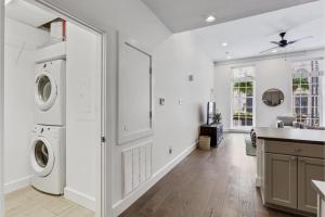 a white laundry room with a washer and dryer at Roami at Bourbon Place in New Orleans