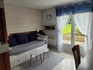 mały pokój z łóżkiem, stołem i oknem w obiekcie Arzon rue de la Plage Résidence Bretagne Douce w mieście Arzon